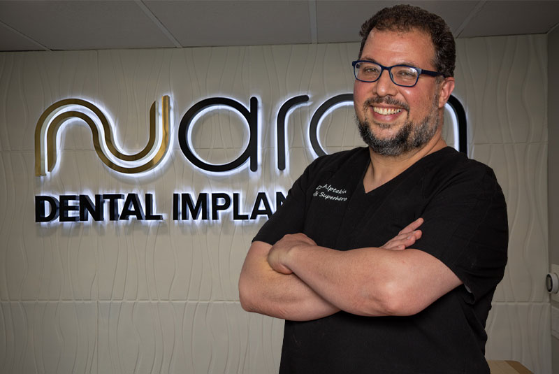 Dr. Sal Infront Of A NuArch Dental Implant Center Sign